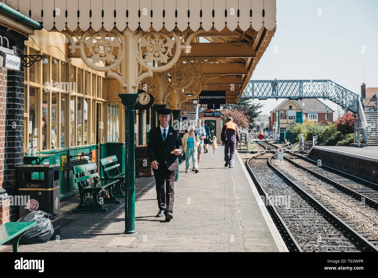 Sheringham, UK - 21 Avril 2019 : Chef de la marche sur la gare de Sheringham avec un sandwich à la main. Sheringham est une ville balnéaire dans le t Banque D'Images