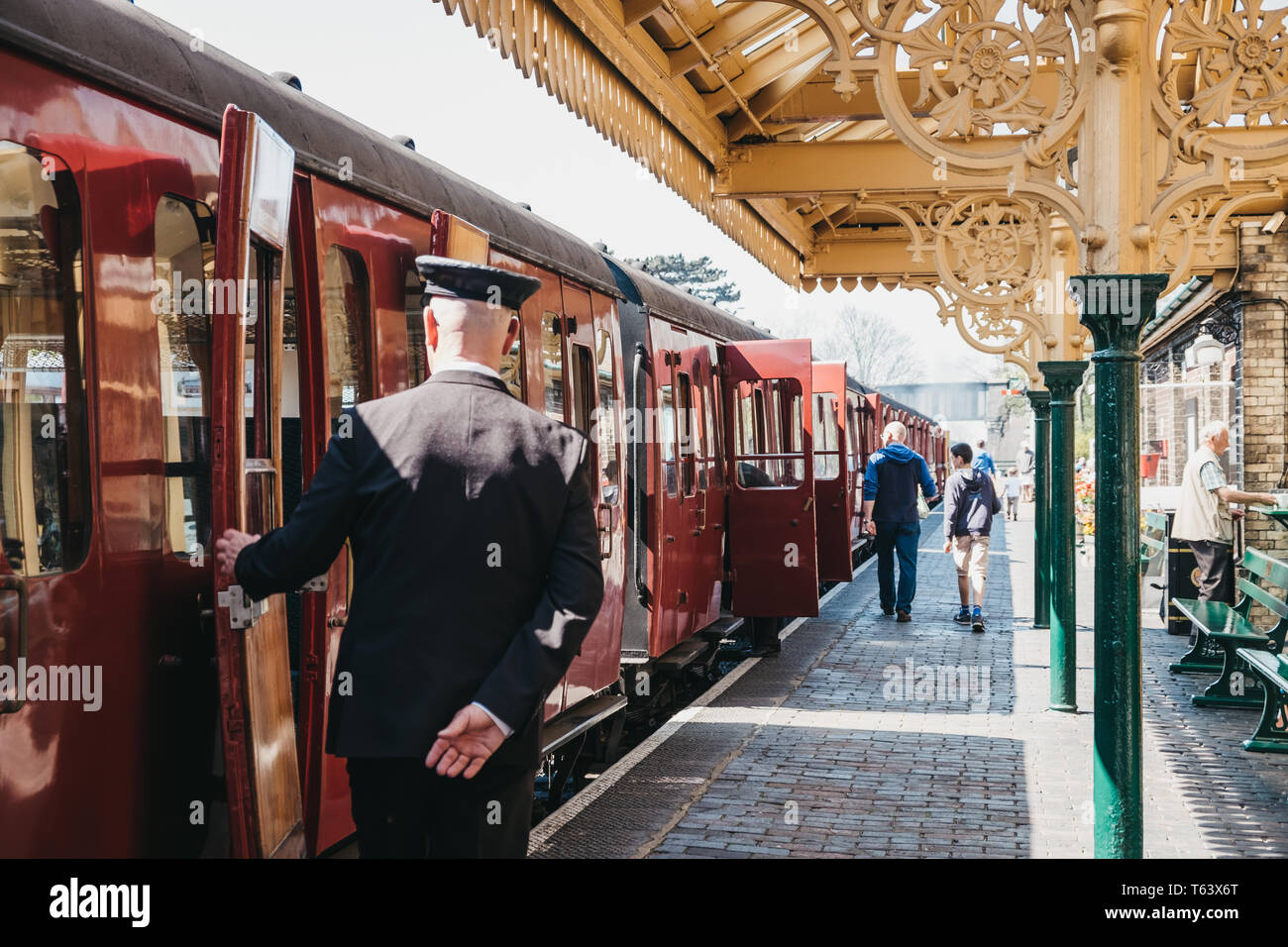 Sheringham, UK - 21 Avril 2019 : Conducteur en uniforme de la fermeture d'une porte de train à vapeur de la ligne de pavot rétro à Sheringham. Sheringham est un Français s Banque D'Images
