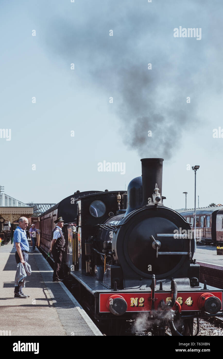 Sheringham, UK - 21 Avril 2019 : le personnel et des passagers par train à vapeur de la ligne Le coquelicot, également connu sous le nom de North Norfolk Railway, un chemin de fer à vapeur du patrimoine Banque D'Images