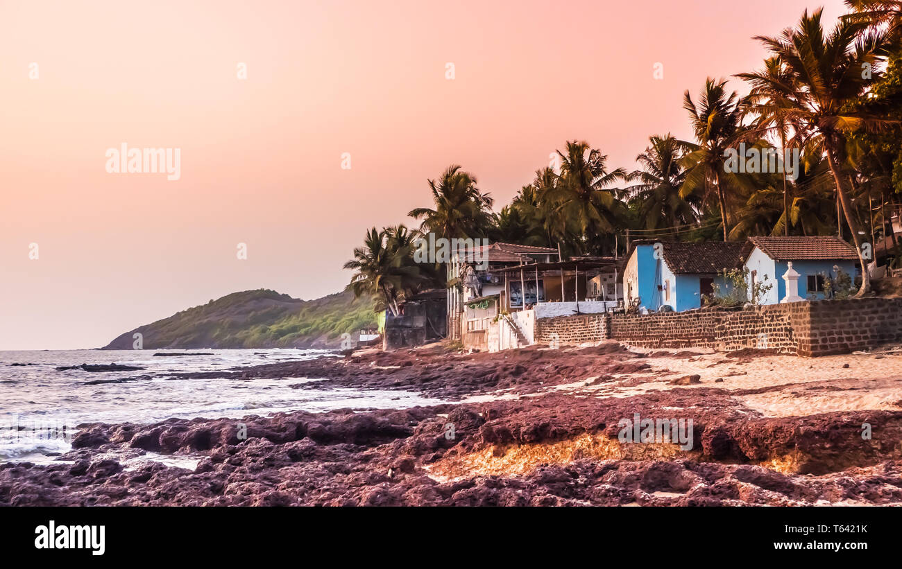 Belle plage d'Anjuna dans le nord de Goa, en Inde. Plage populaire destination vacances à Goa avec bleu de la mer d'Oman, vagues, rochers et plage typique Banque D'Images