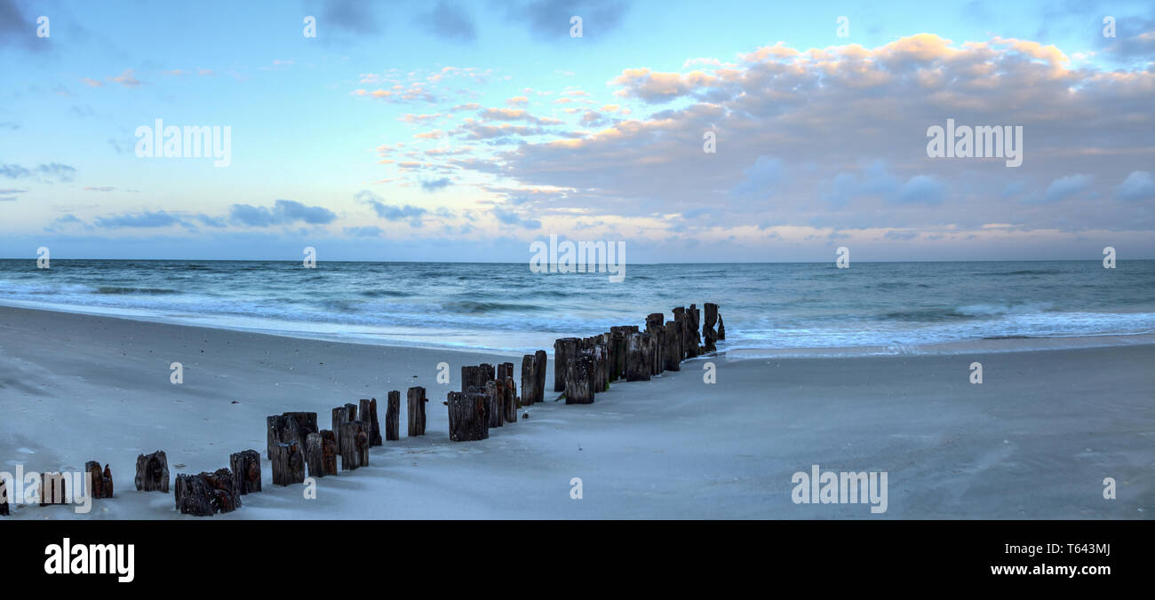 L'aube sur une jetée en ruine sur la plage de Port Royal de Naples, en Floride. Banque D'Images