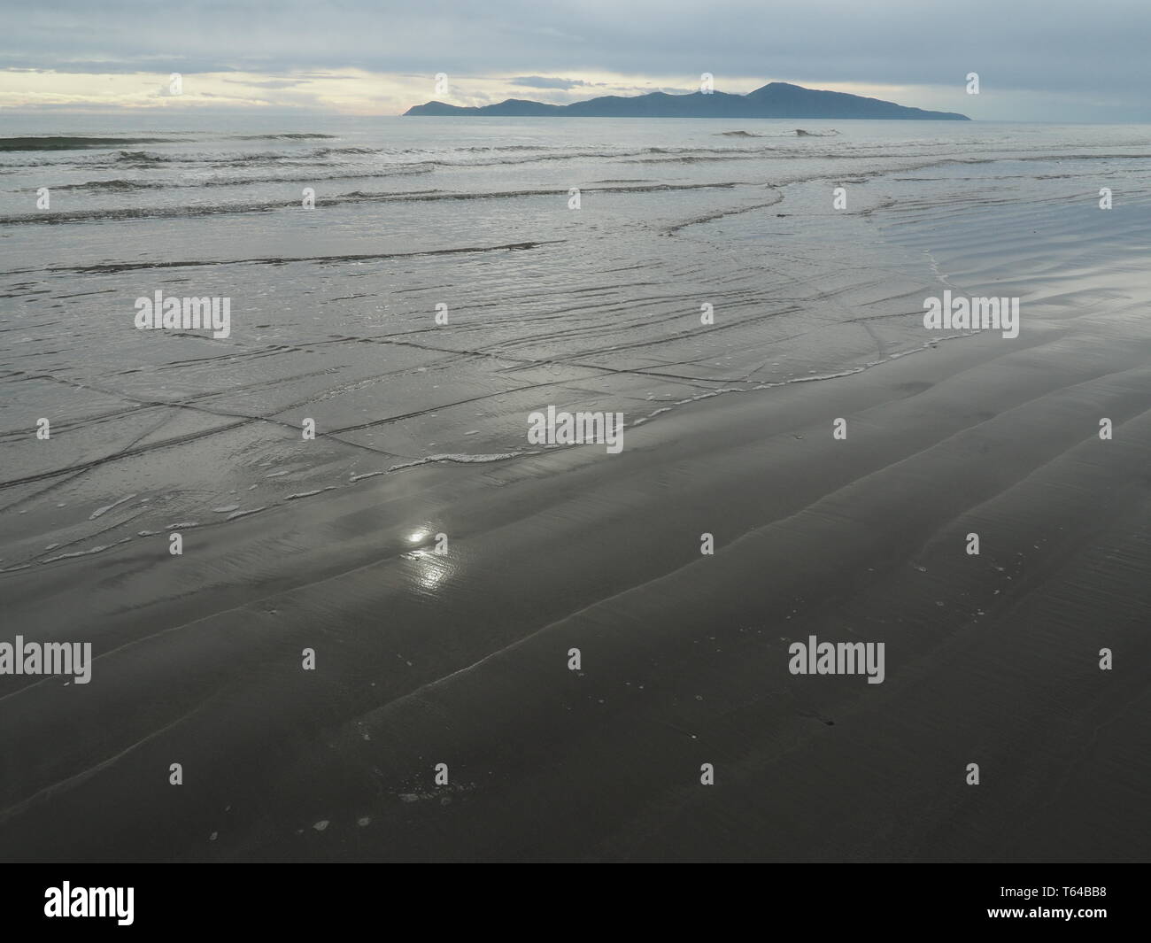 L'Île Kapiti juste au nord de Wellington, NZ, la fin de l'après-midi, avec le soleil reflété sur sable gris Banque D'Images