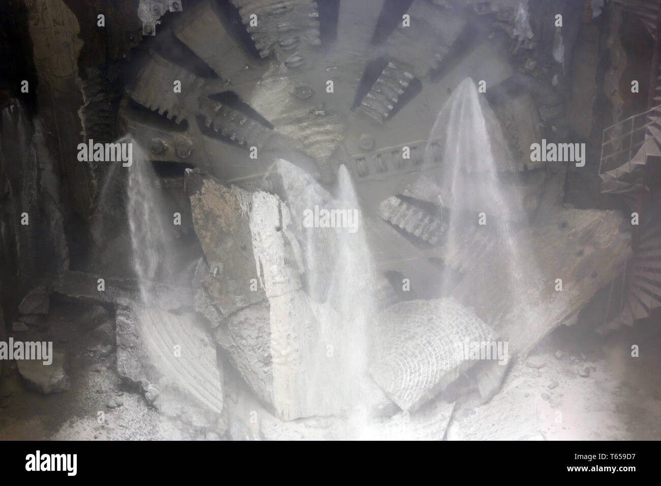 Avant de tunnelier élément head est vu tourner sur une station de métro en construction. La poussière et l'eau. Banque D'Images