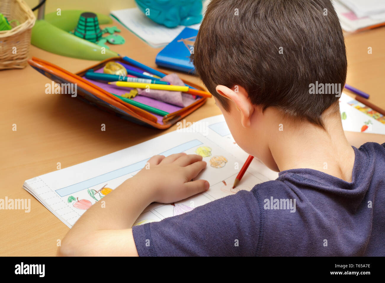 Boy doing homework avec crayon de couleur Banque D'Images