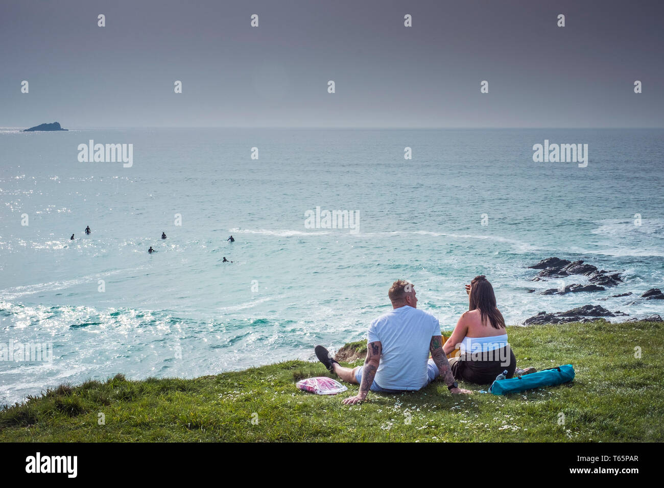 Les vacanciers détente sur la côte, dans la baie de Fistral Newquay en Cornouailles. Banque D'Images