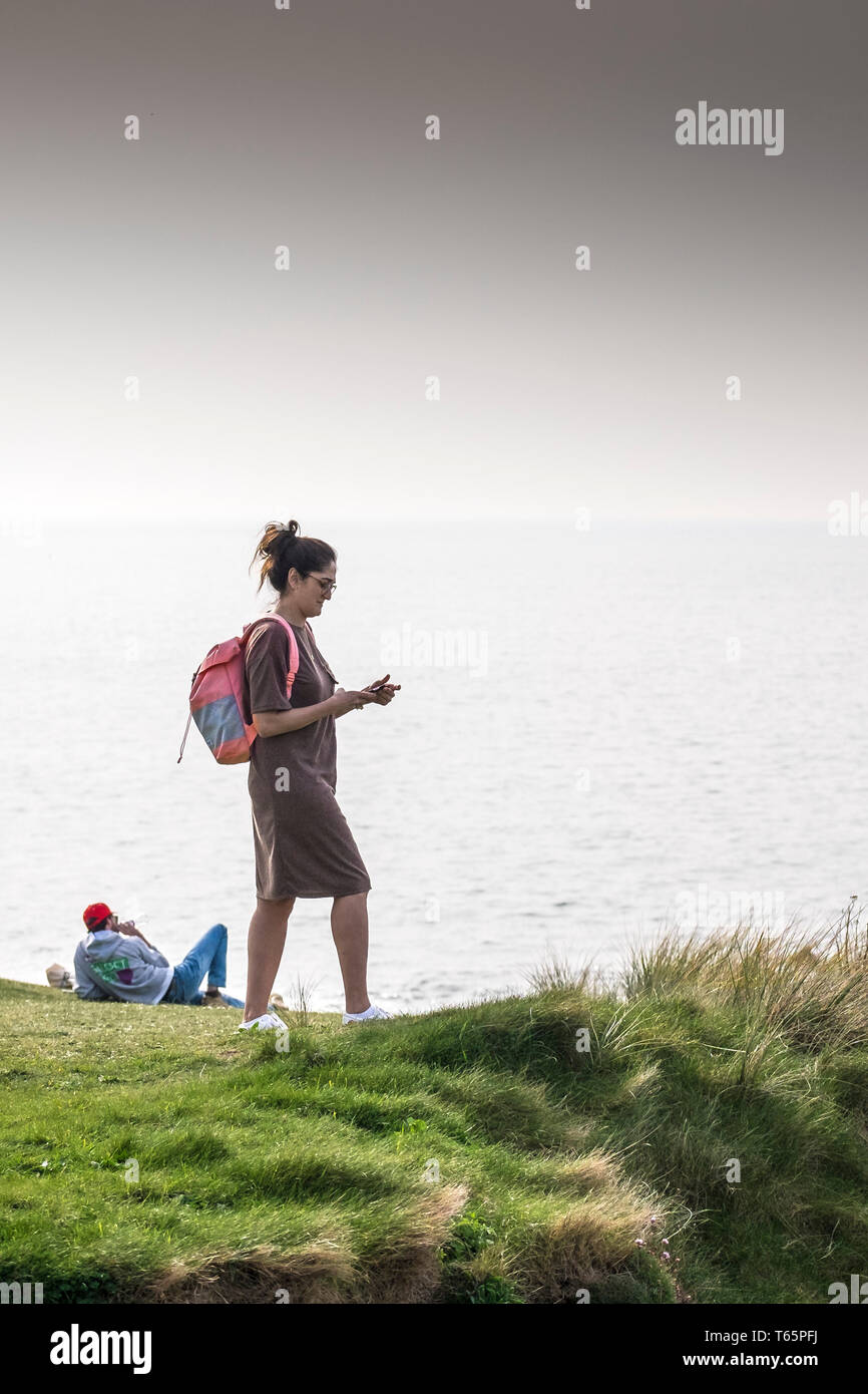 Les touristes se détendre sur la côte donnant sur la mer, sur la Pointe à Newquay en Cornouailles. Banque D'Images