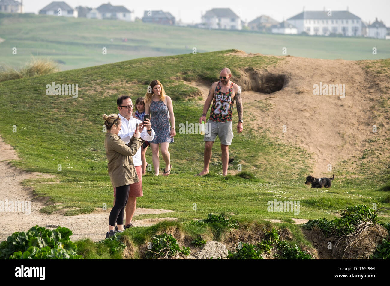 Les touristes se détendre sur la côte donnant sur la mer, sur la Pointe à Newquay en Cornouailles. Banque D'Images