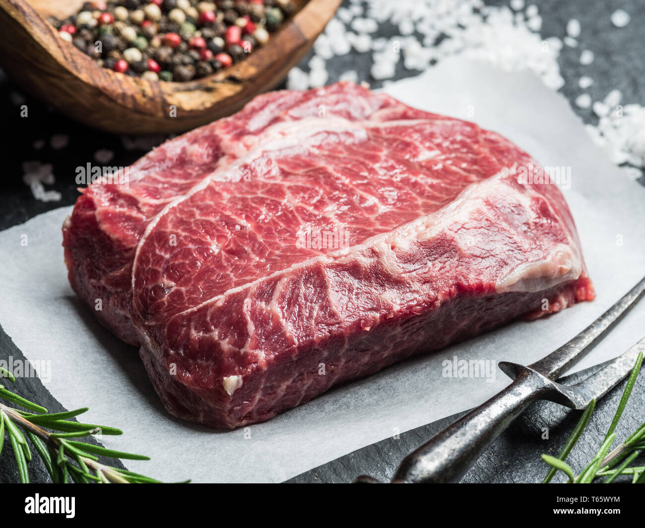 La lame supérieure ou steak steak de boeuf sur le conseil de graphite avec des herbes et épices. Banque D'Images