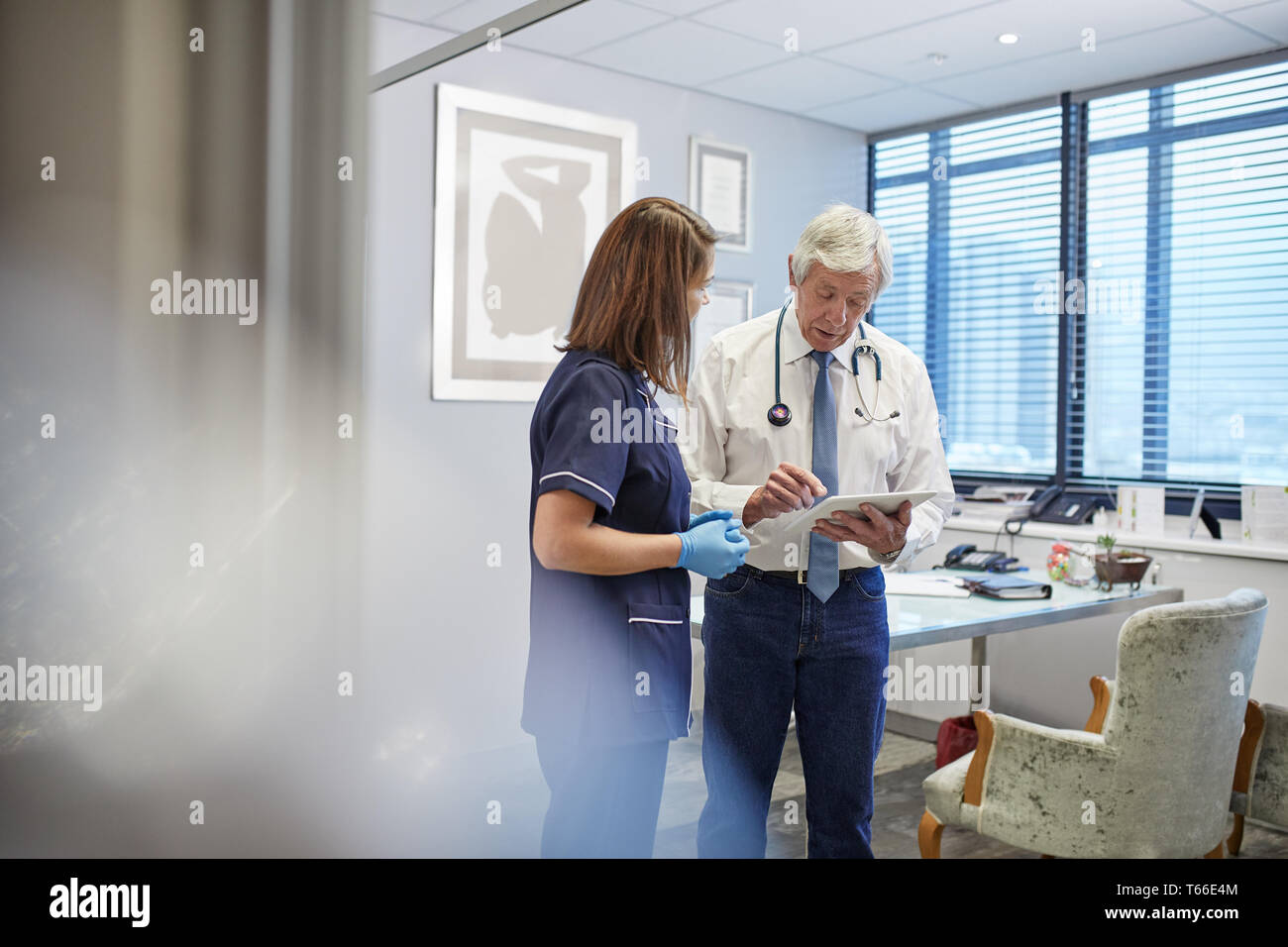 Doctor and nurse with digital tablet talking, conseil en pratique clinique office Banque D'Images