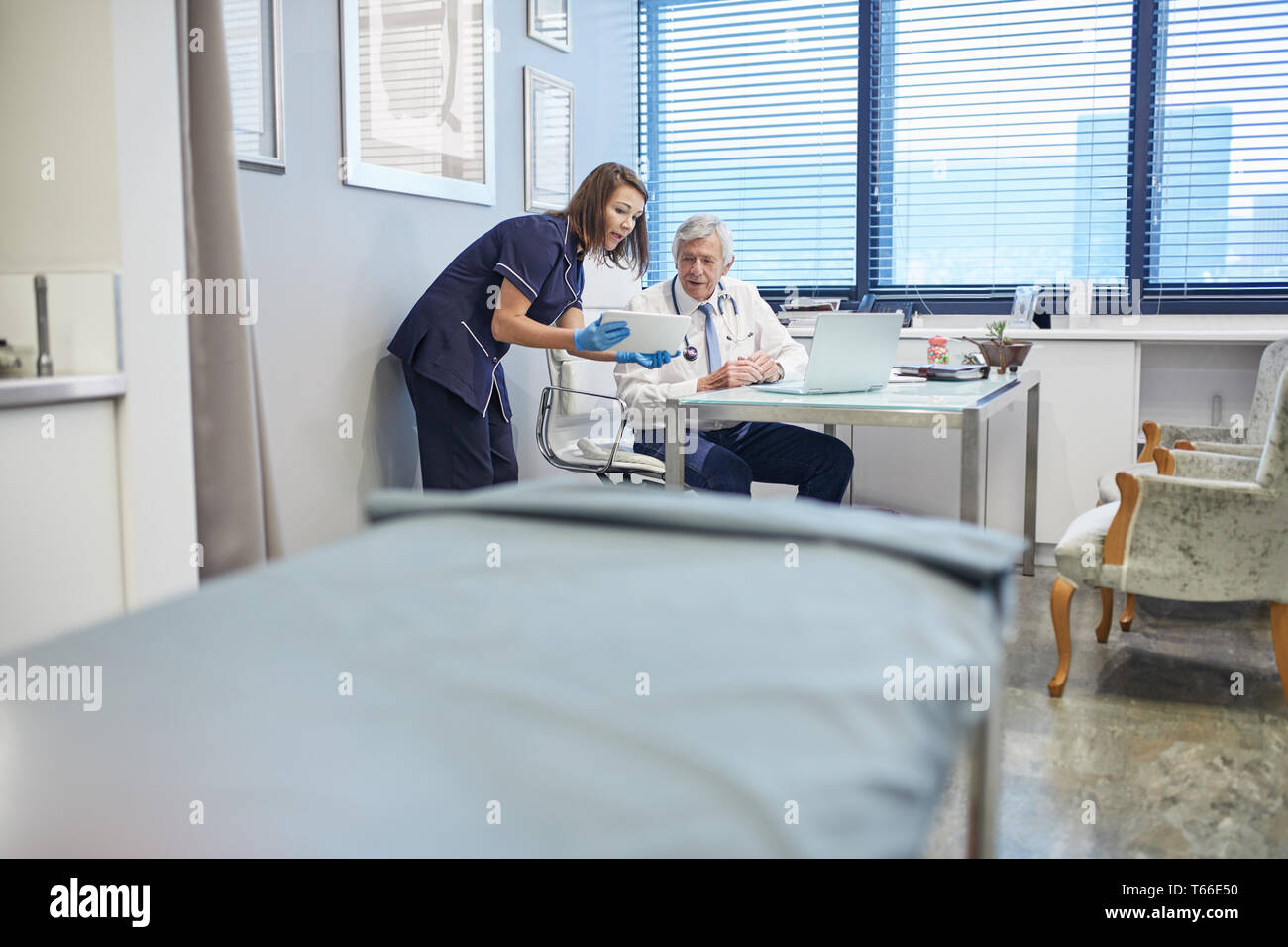 Doctor and nurse using digital tablet, conseil en pratique clinique office Banque D'Images
