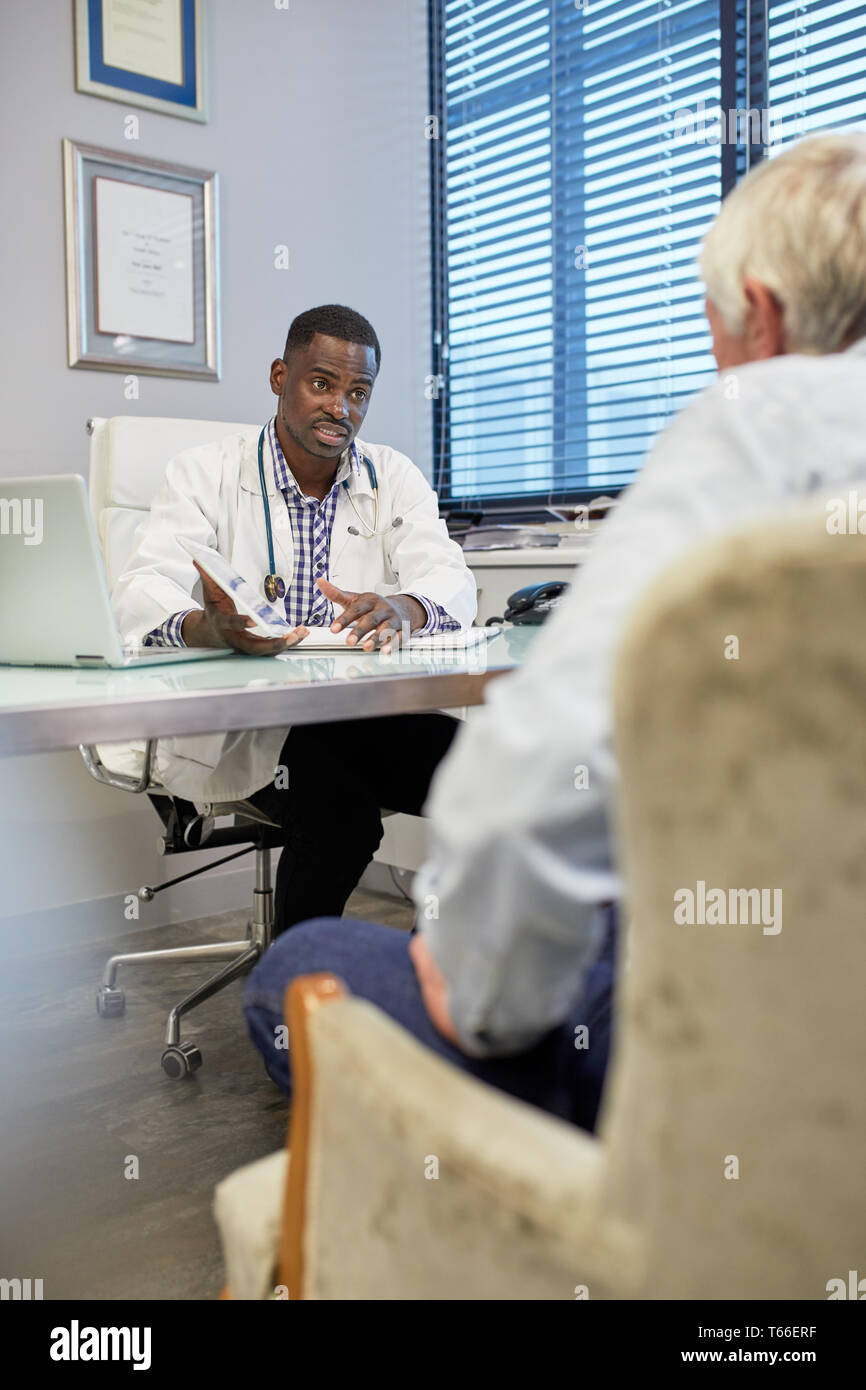 Médecin with digital tablet talking to patient in office de médecins Banque D'Images