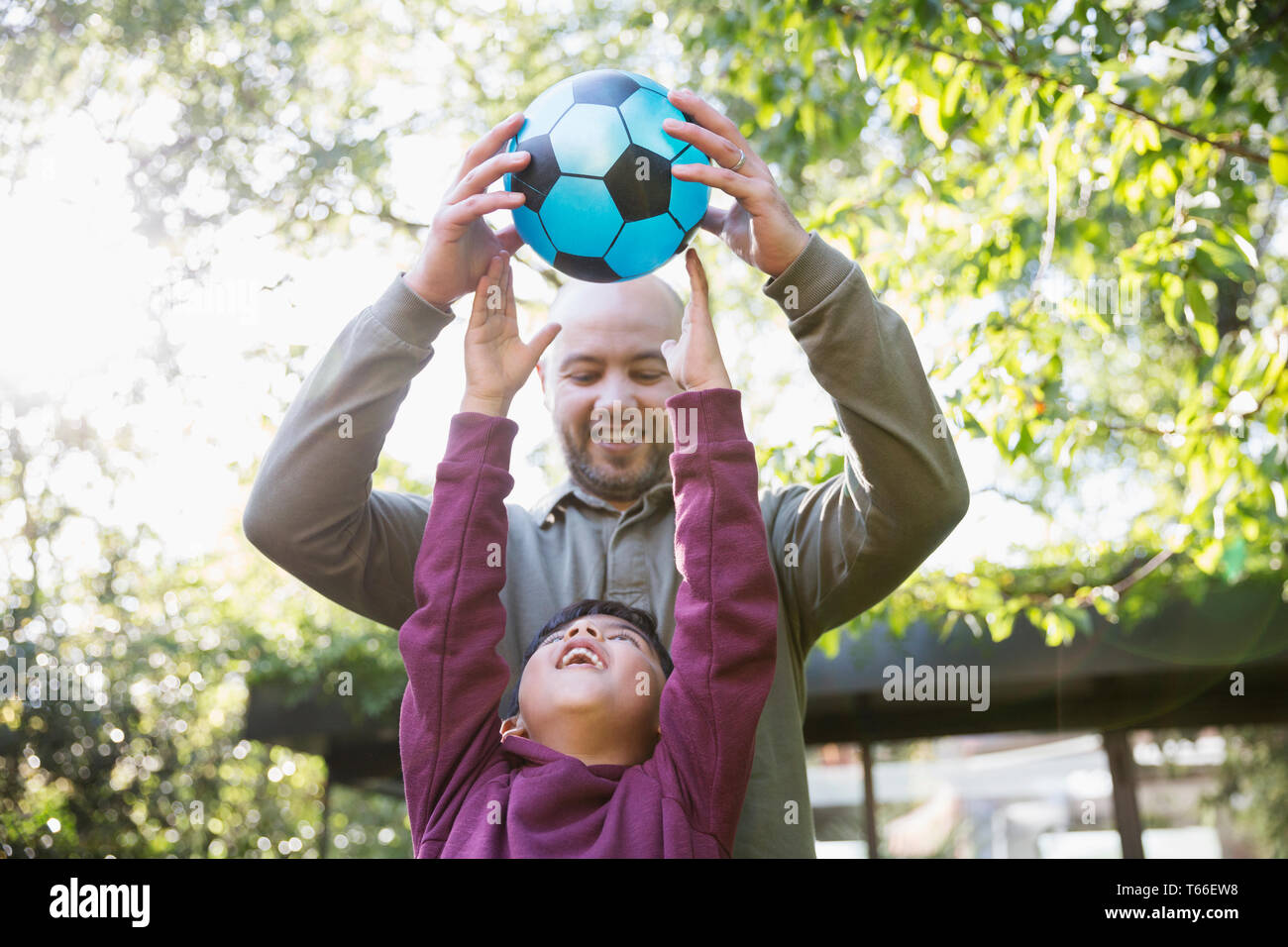 Père et fils joue au soccer dans sunny park Banque D'Images