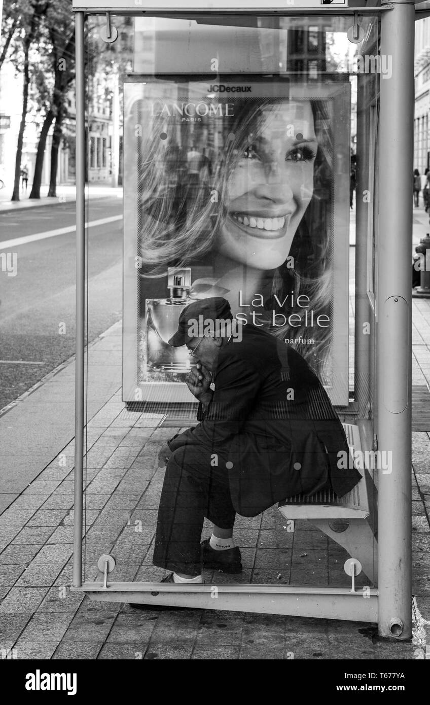 Sourire de Julia Roberts en contraste avec la solitude d'un vieil homme en attendant le bus, Lyon Banque D'Images