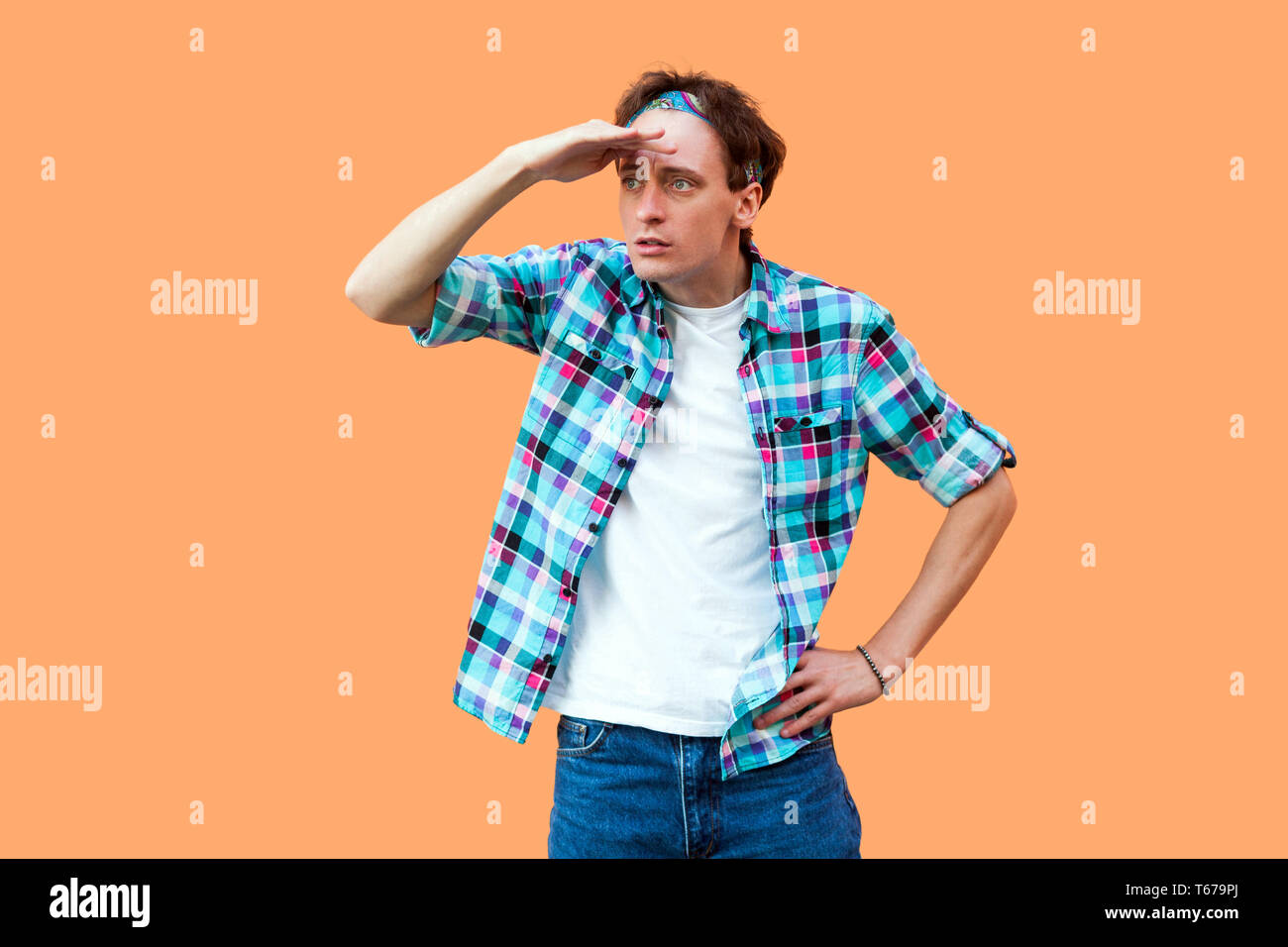 Portrait de jeune homme sérieux attentionné décontracté en chemise à  carreaux bleu debout avec serre-tête main sur front et à trop loin pour  trouver quelque chose Photo Stock - Alamy