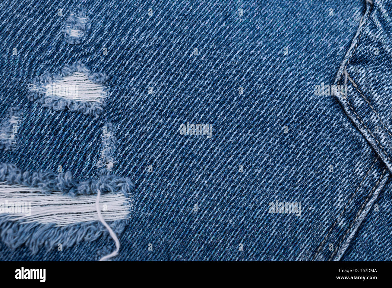 Texture denim bleu avec des trous et des threads. Selectibe fokus
