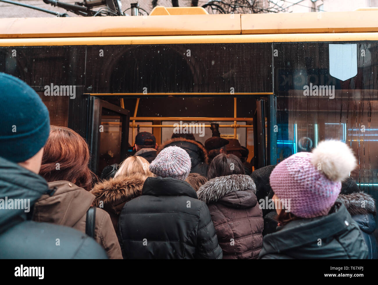 De nombreuses personnes non identifiées sont en attente de transport de la ville à l'arrêt de bus Banque D'Images