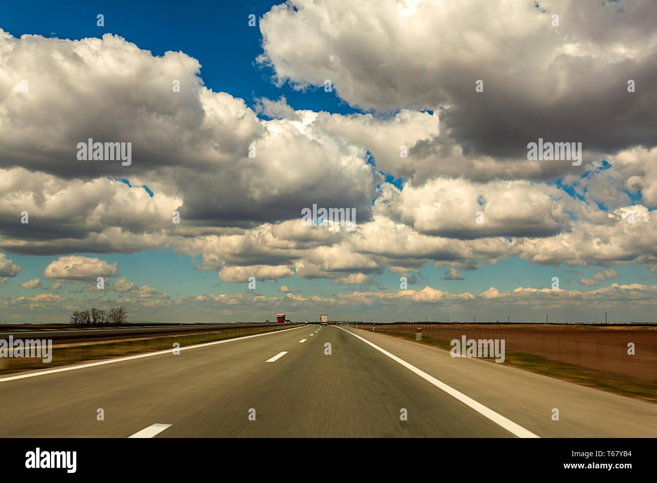 Location de voiture rapide. Motion de la vitesse sur la route fond d'image dans la campagne avec de beaux nuages Banque D'Images