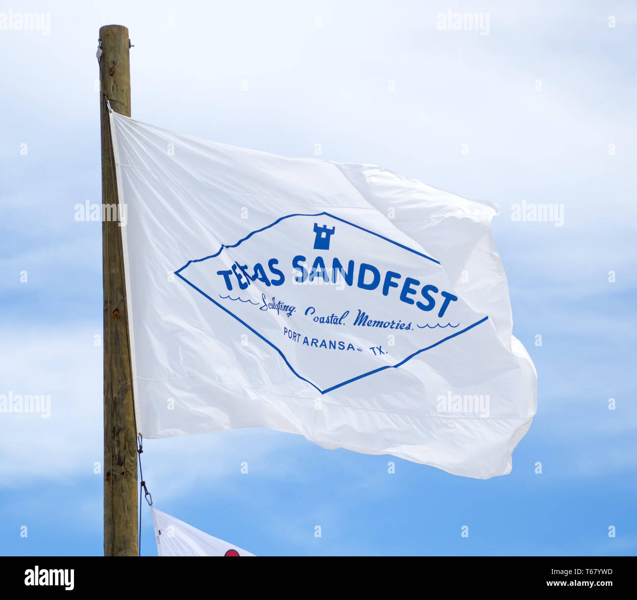 Le Texas Sandfest drapeau flotte contre un ciel bleu avec des nuages blancs au Texas 2019 Sandfest à Port Aransas, Texas USA. Banque D'Images