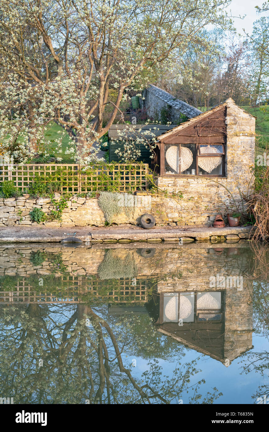 Canal d'Oxford et le jardin reflets dans le soleil de printemps au petit matin. Shipton on Cherwell, Oxfordshire, Angleterre Banque D'Images