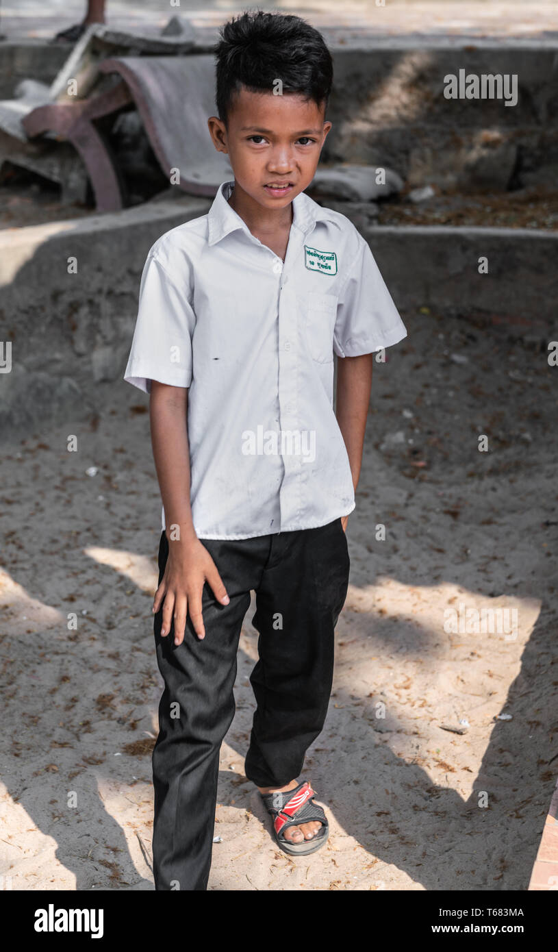 Sihanoukville, Cambodge - Mars 15, 2019 : de jeunes garçon cambodgien avec  chemise blanche et pantalon noir sur les tongs dans la terre près de Phsar  Leu mar Photo Stock - Alamy