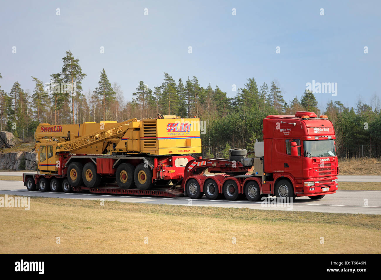 Paimio, Finlande - le 19 avril 2019 : Red Scania 164G truck de Haro Asko Oy transporte SevenLift sur grue portuaire remorque plate-forme goutte le long d'une autoroute. Banque D'Images