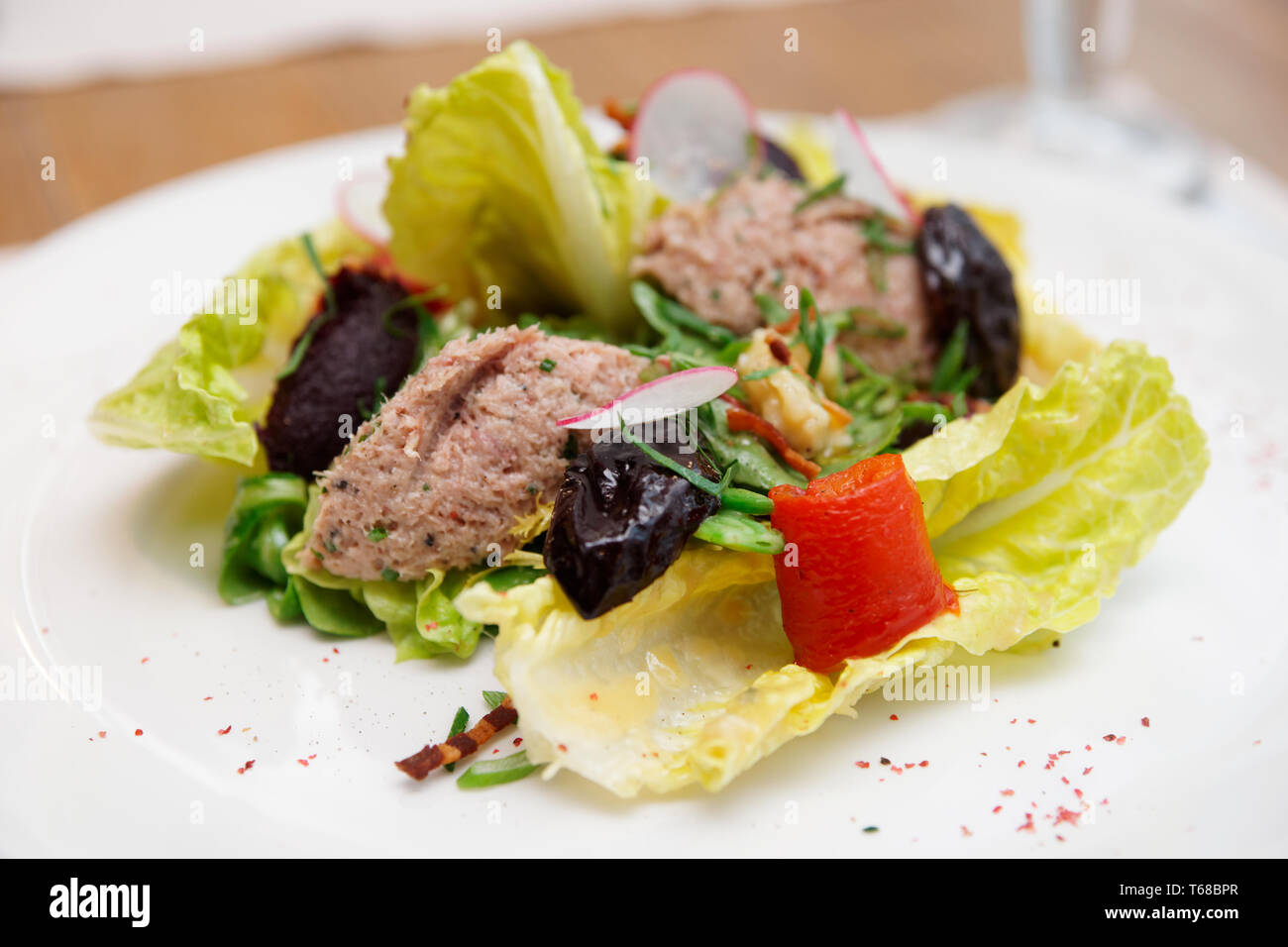 Salade créative avec des pruneaux et de la pâte de poisson sur la plaque, close-up Banque D'Images