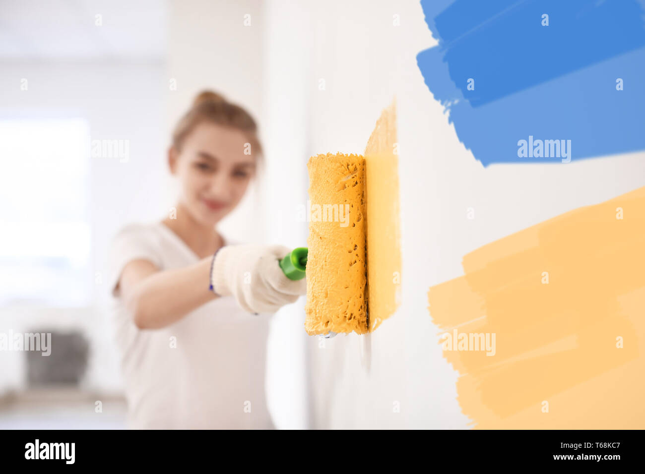 Mur peinture décorateur femelle avec rouleau à l'intérieur Banque D'Images