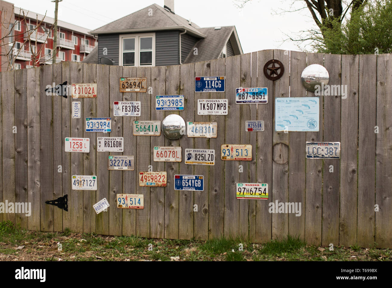 Une collection de plaques d'immatriculation vintage accroché à une clôture en bois dans le quartier de la place de la fontaine d'Indianapolis, Indiana, USA. Banque D'Images