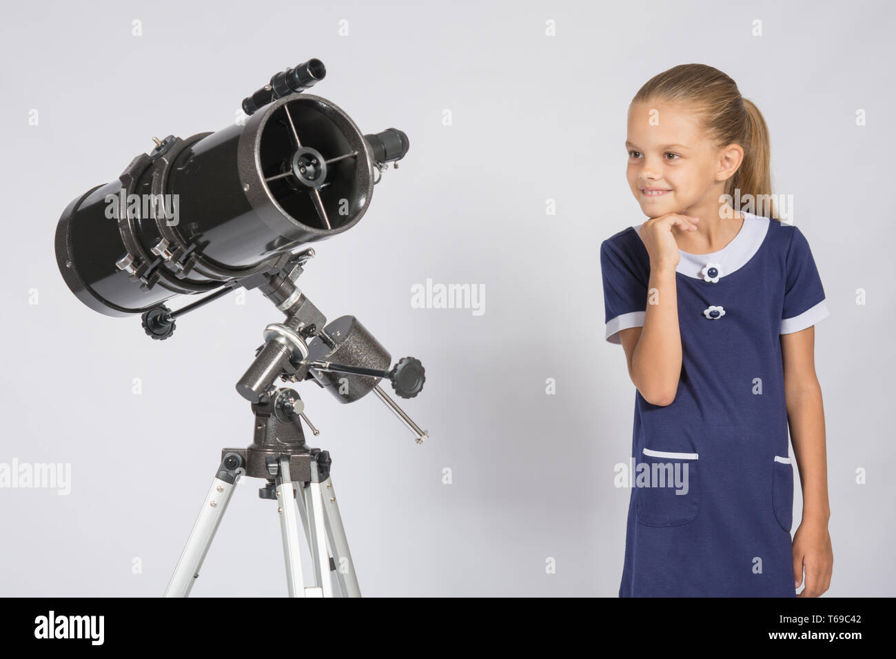 Fille de sept ans avec intérêt à la recherche d'un télescope à réflecteur Banque D'Images