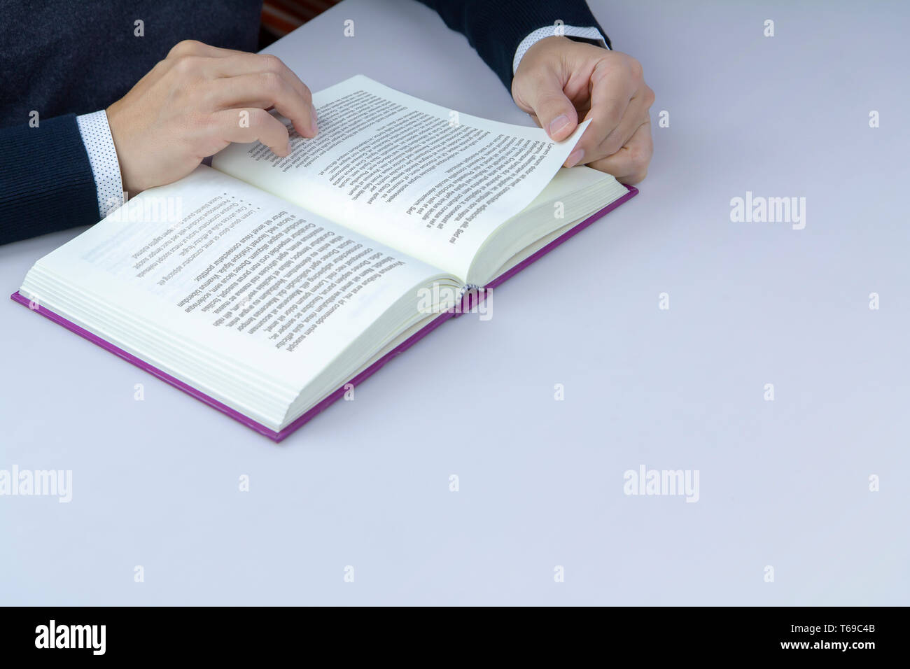 Close-up of a man reading a book in library. Isolé sur blanc et de bureau composé d'un coin supérieur gauche avec copie espace en bas à droite avec fictitiou Banque D'Images