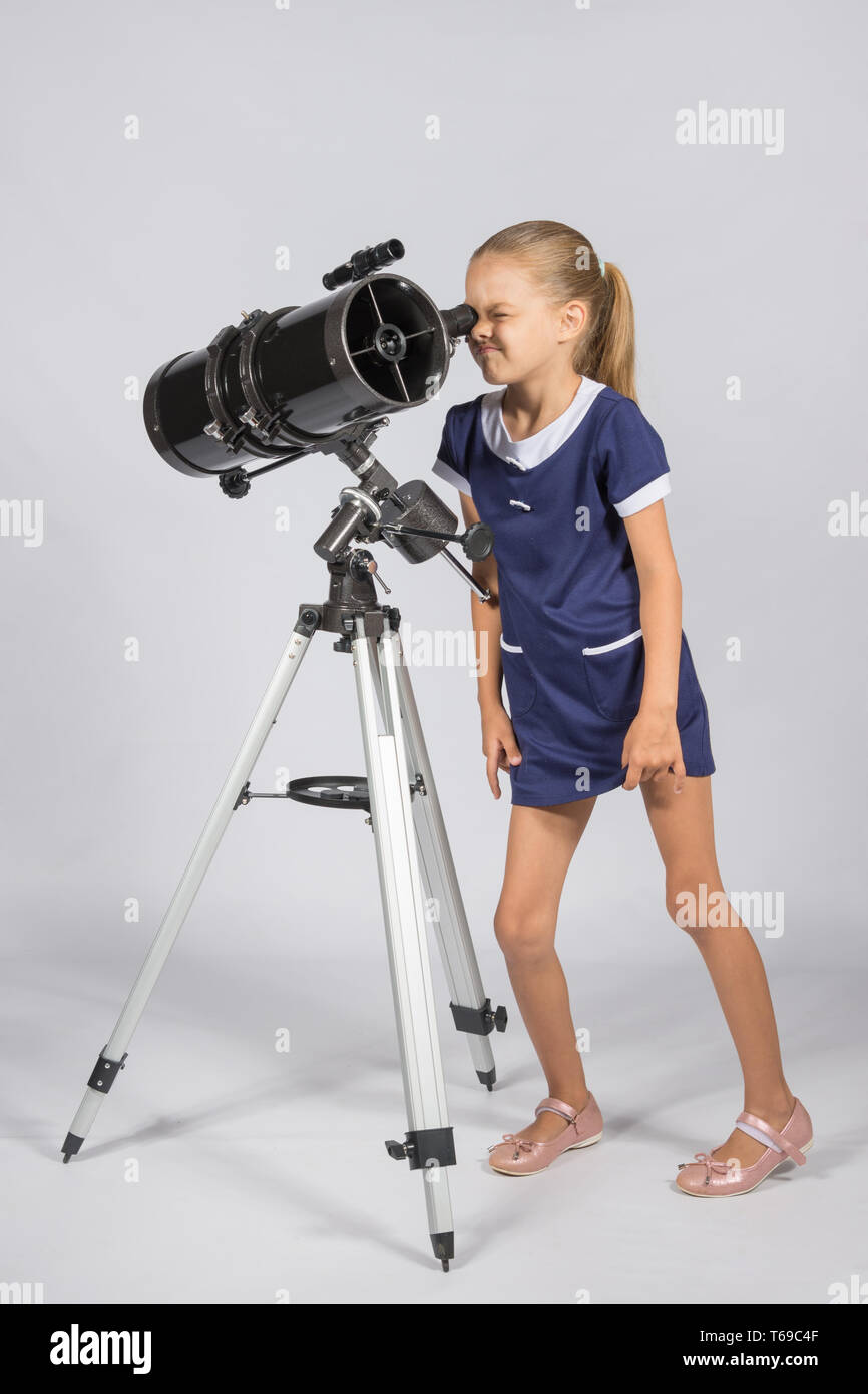Jeune astronome semble drôle à travers l'oculaire du télescope Banque D'Images