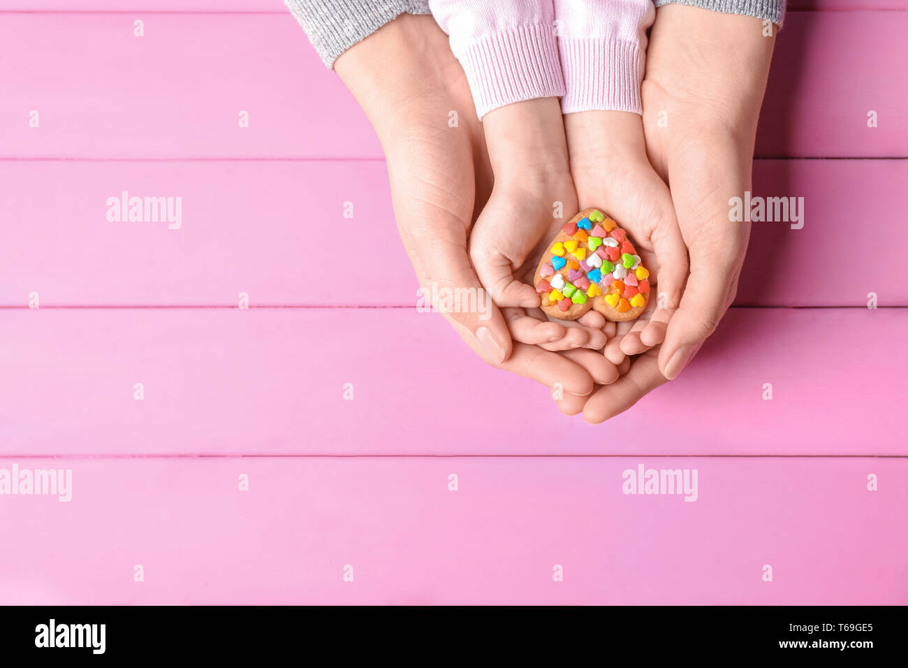 La mère et l'enfant avec des cookies en forme de cœur sur fond de bois Banque D'Images