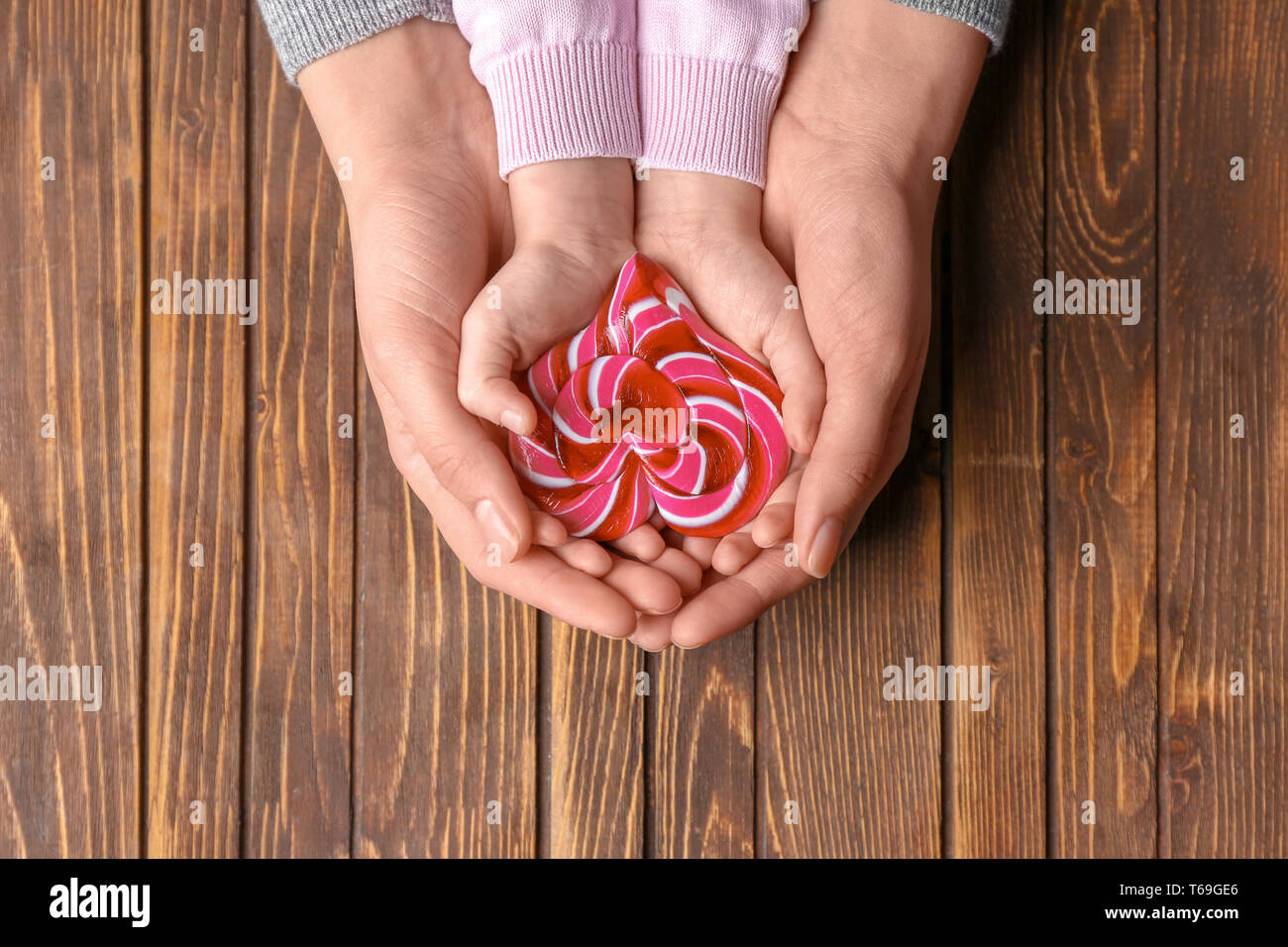 La mère et l'enfant avec des bonbons en forme de cœur sur fond de bois Banque D'Images