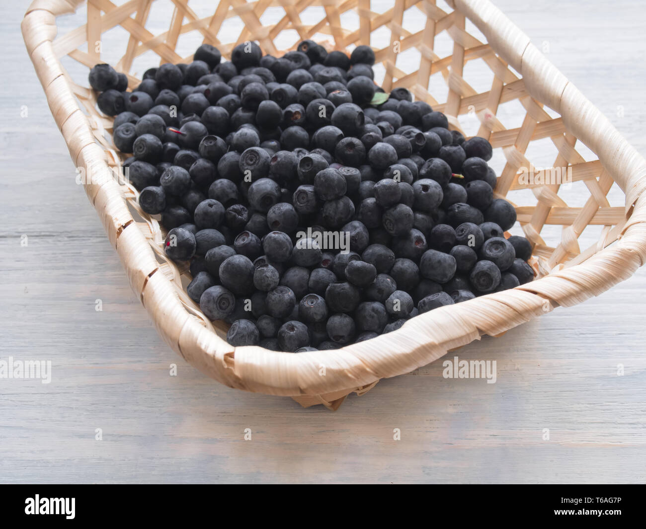 Petit panier en osier avec des bleuets sauvages Banque D'Images