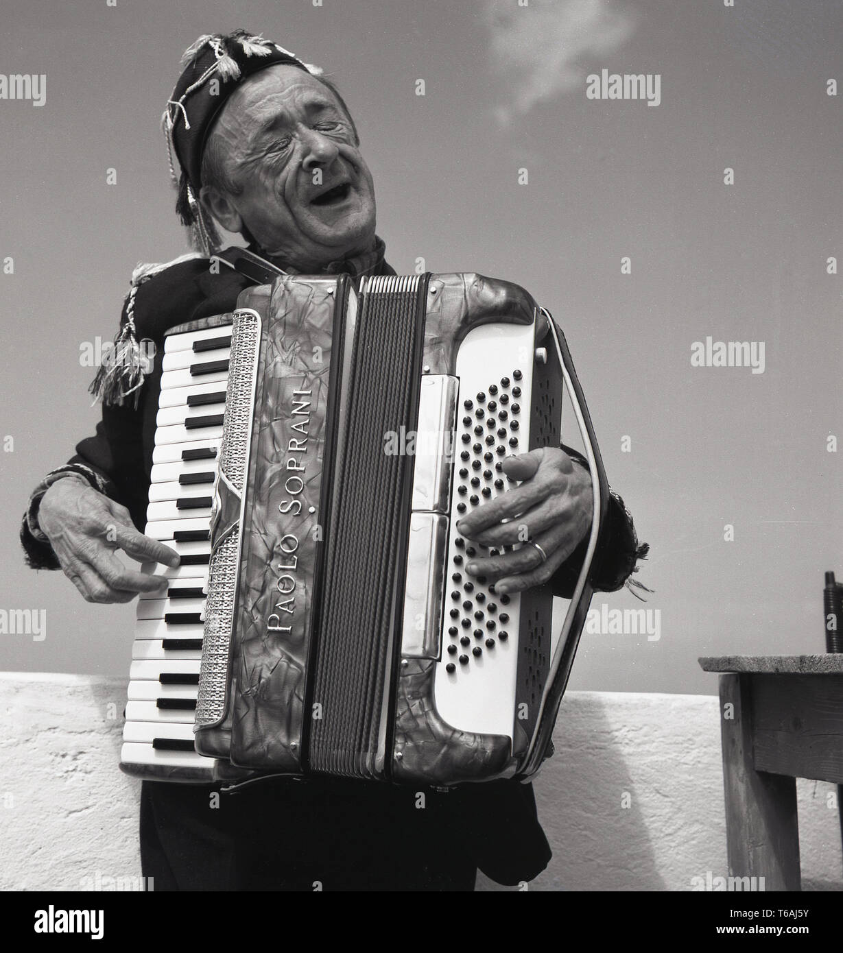 Années 1950, historiques, homme musicien de rue ou l'interprète, un homme âgé à l'extérieur de jouer d'un instrument de musique, l'accordéon, de l'Italie. Il joue un style accordéon piano Paolo Soprani avec un clavier musical. Paolo Soprani, un ouvrier de Castelfidardo, commencé en 1864 et a été le premier fabricant d'accordéons dans ce qui allait devenir un élément important de l'industrie italienne. Banque D'Images