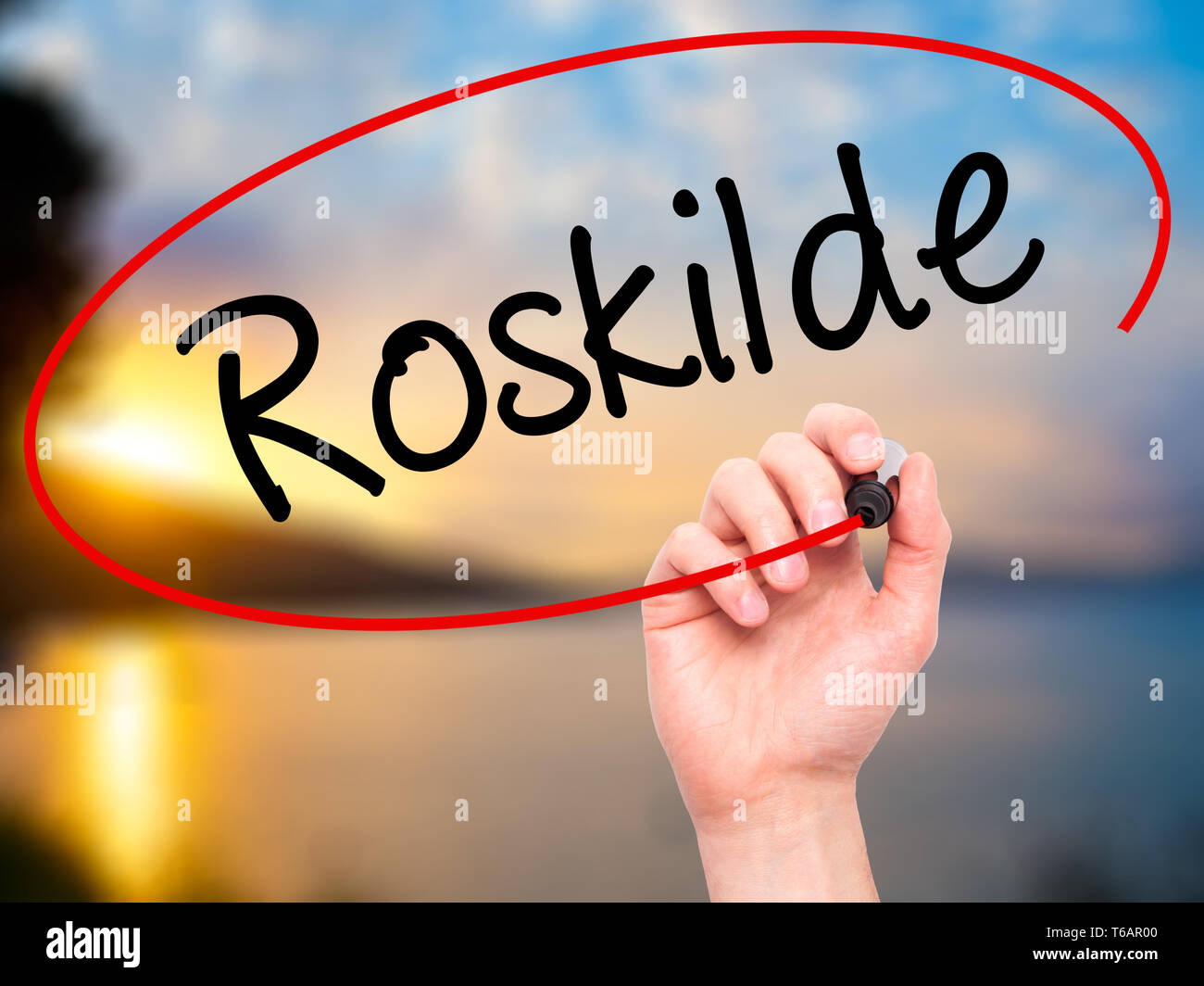Man main écrit Roskilde avec marqueur noir sur l'écran visuel Banque D'Images