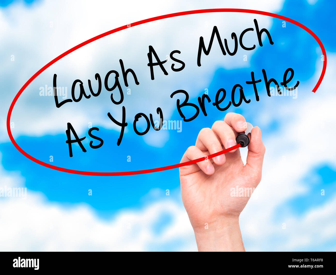 Man main écrit rire autant que vous respirez avec marqueur noir sur l'écran visuel. Banque D'Images