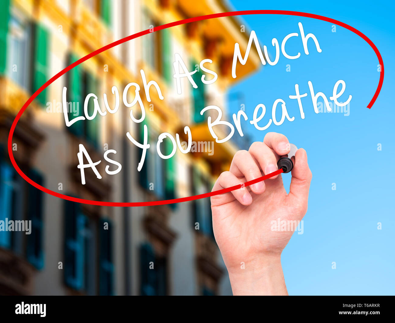 Man main écrit rire autant que vous respirez avec marqueur noir sur l'écran visuel. Banque D'Images