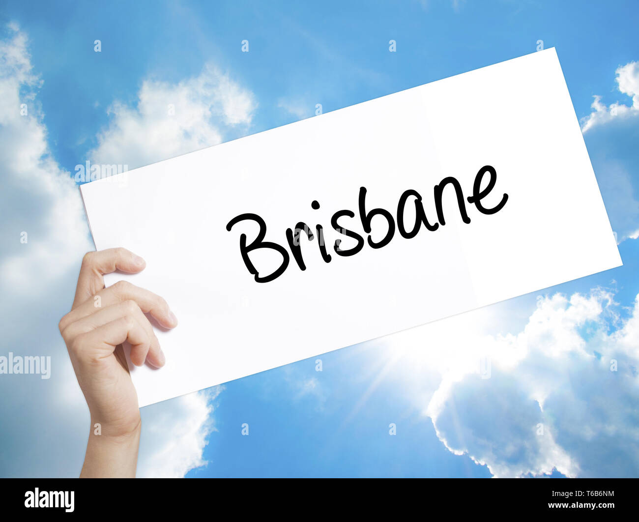 Signe de Brisbane sur du papier blanc. Tenir la main de l'homme papier avec texte. Isolé sur fond de ciel Banque D'Images