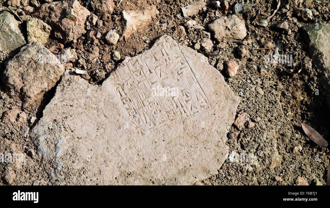 Vue rapprochée de la plaque avec texte sumérien cunéiforme dans les ruines de la rue de procession de l'ancienne Babylone à Hillah, Iraq Banque D'Images