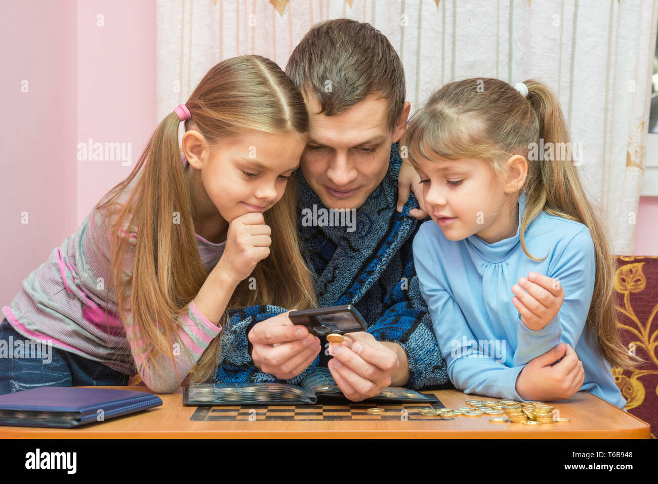 Le pape indique aux enfants une pièce à travers une loupe Banque D'Images Le pape indique aux enfants une pièce à travers une loupe Banque D'Images