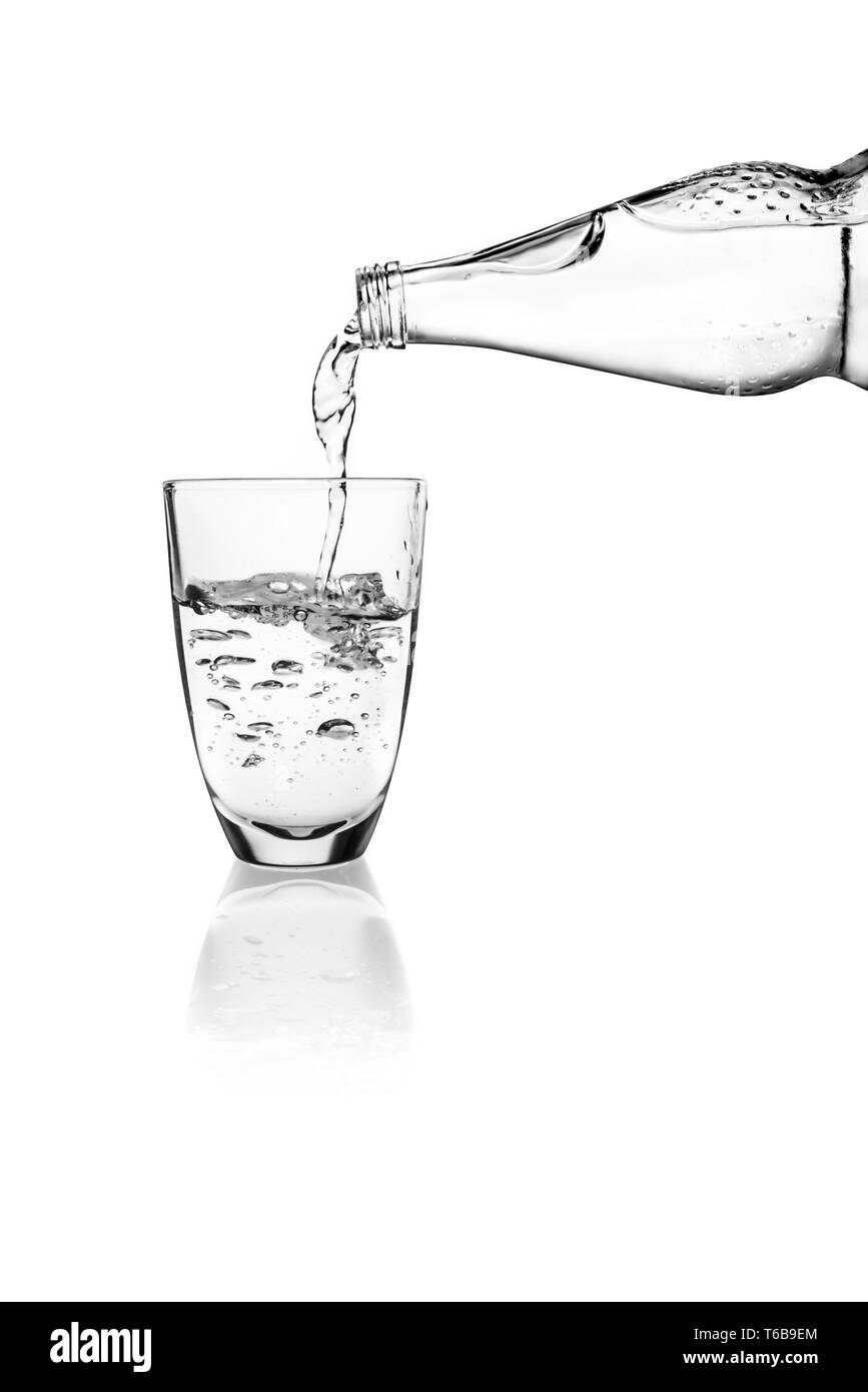 Verser de l'eau dans un verre sur un fond blanc Banque D'Images