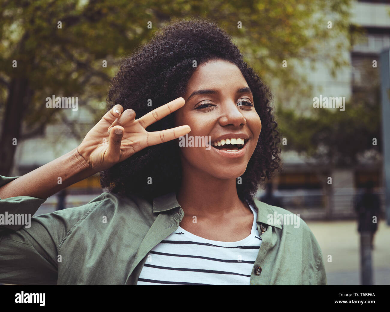 Smiling young woman showing peace sign Banque D'Images