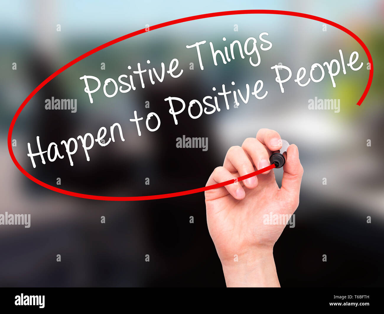 Man main écrit des choses positives se produire pour les personnes positives avec marqueur noir sur l'écran visuel Banque D'Images
