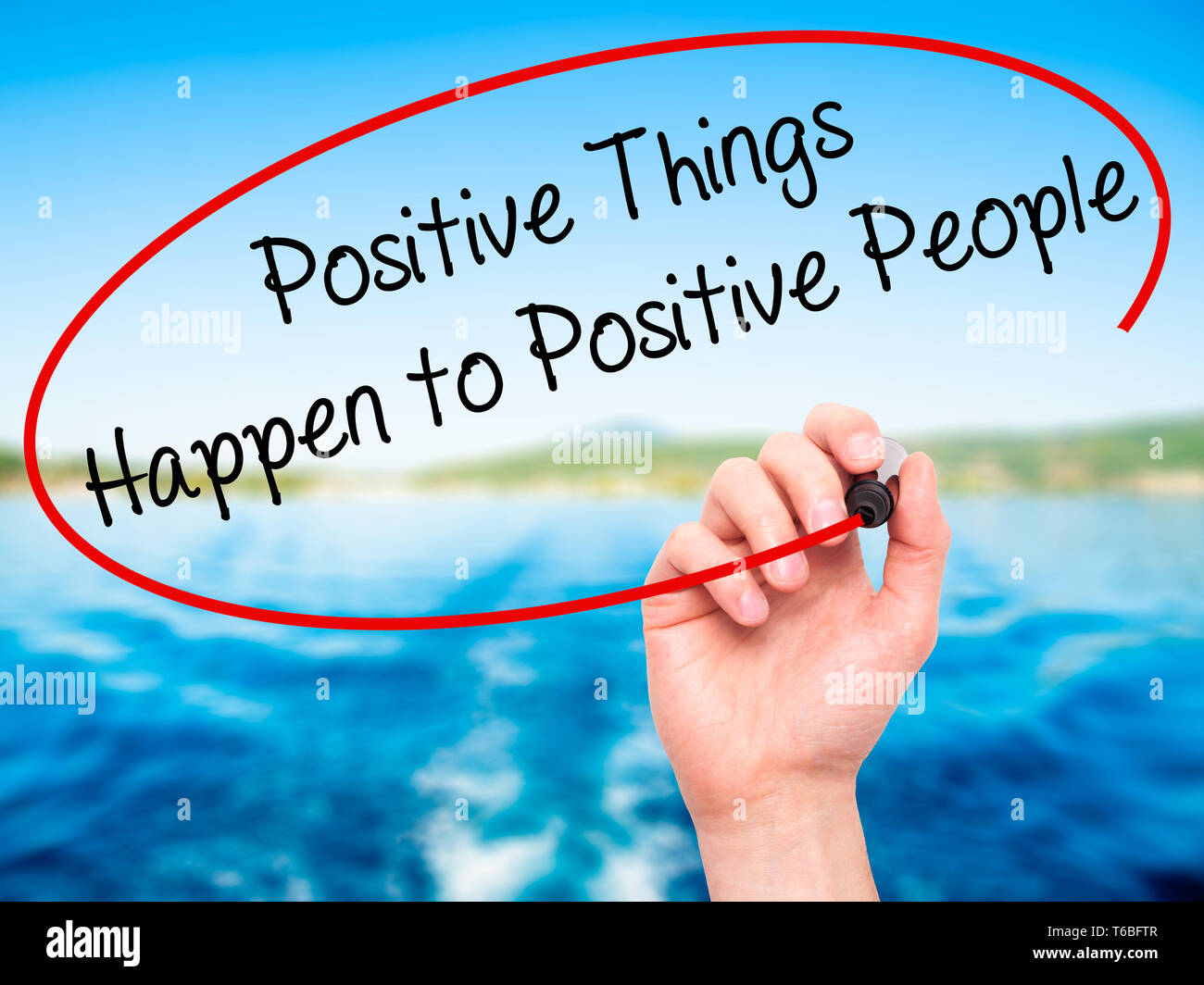 Man main écrit des choses positives se produire pour les personnes positives avec marqueur noir sur l'écran visuel Banque D'Images