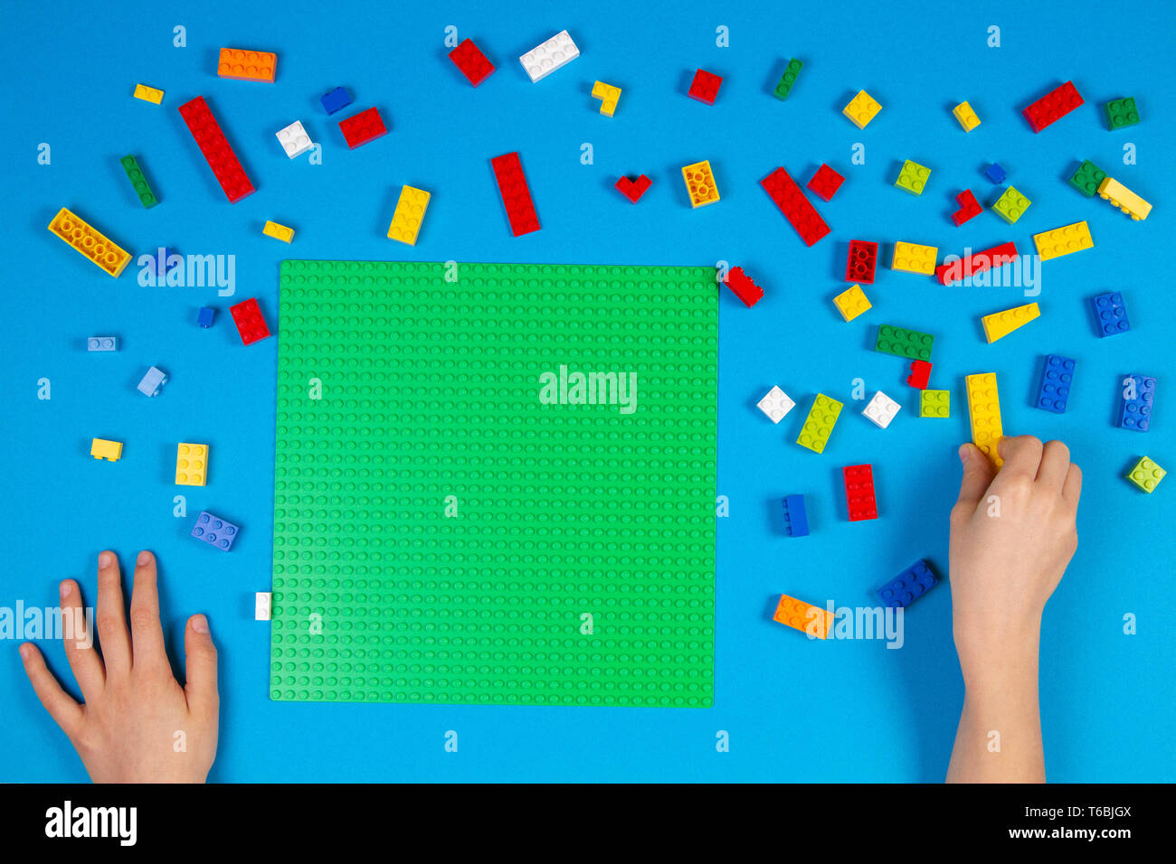 Les mains des enfants jouer avec des blocs Lego colorés sur la table Banque D'Images