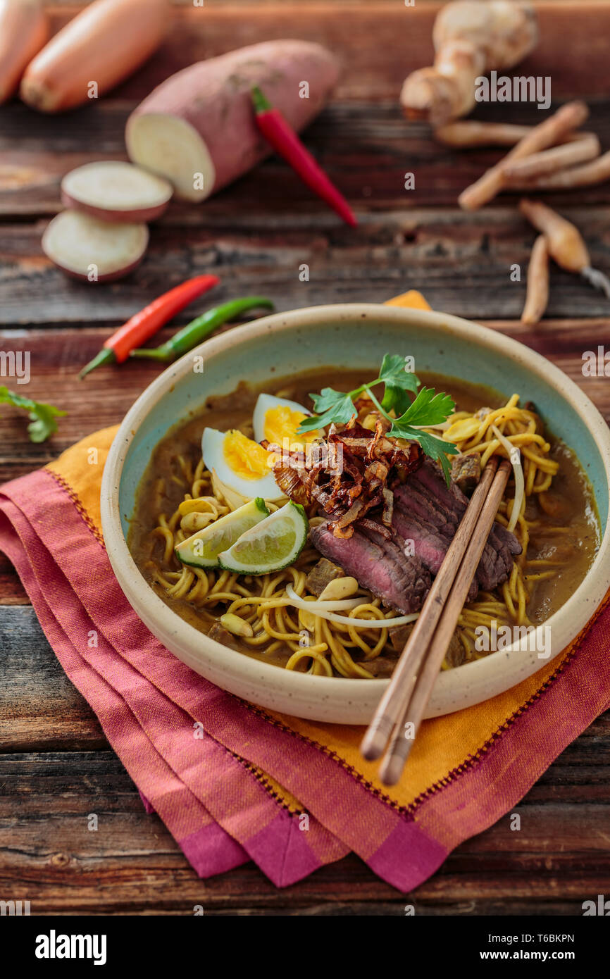 Bol de spicy mee rebus avec des baguettes, une cuisine malaisienne Banque D'Images
