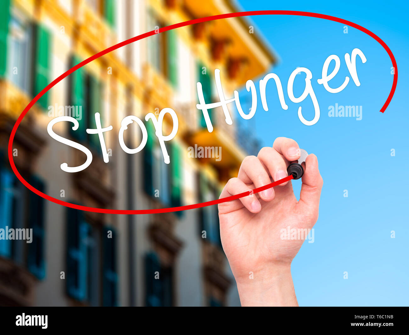 Man main écrit cesser la faim avec marqueur noir sur l'écran visuel Banque D'Images