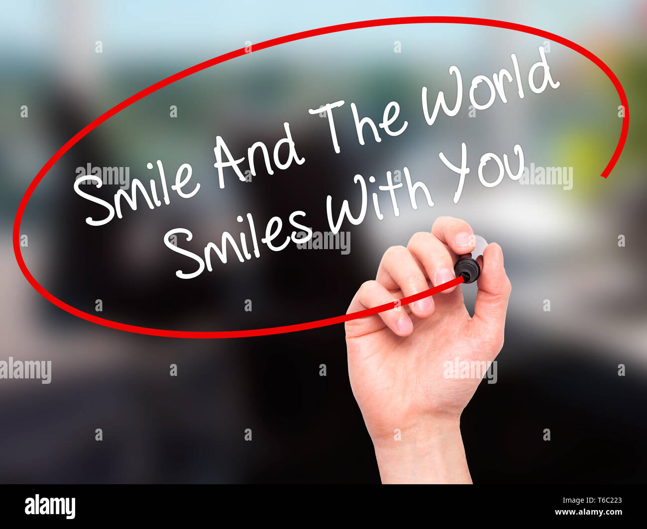 La main de l'homme sourire écrit et le monde vous sourit avec marqueur noir sur l'écran visuel Banque D'Images