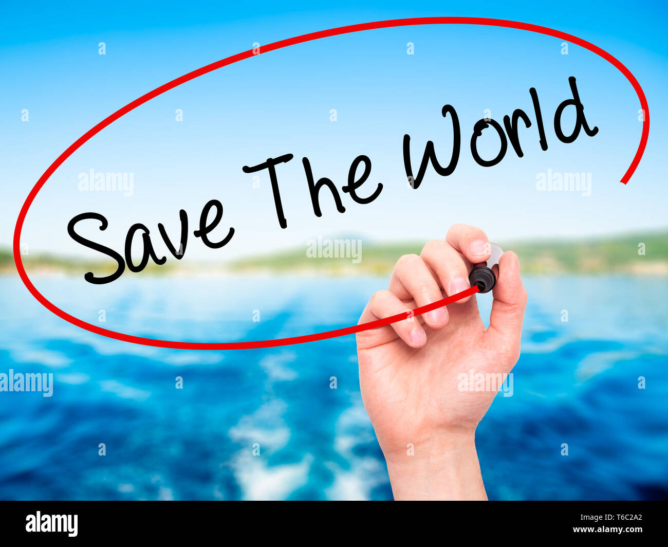 Man main écrit sauver le monde avec marqueur noir sur l'écran visuel. Banque D'Images